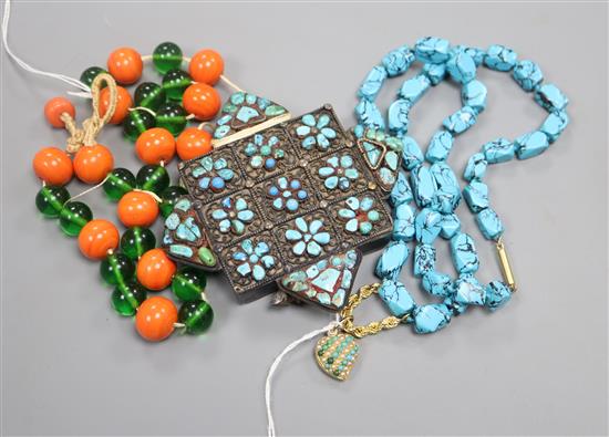 A Tibetan turquoise-set prayer box (now on glass bead suspension) and a turquoise necklace hung with a yellow metal locket.